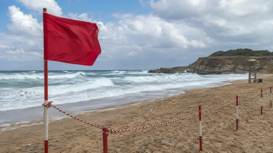 Editorial illustration of rough waves, a red safety flag and an empty beach on the Şile coast